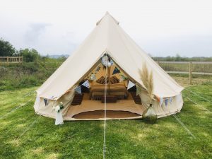 Bell tent on lawn by pond
